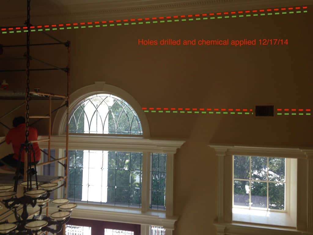 Two-story entry with dotted lines marking where holes were drilled and treated